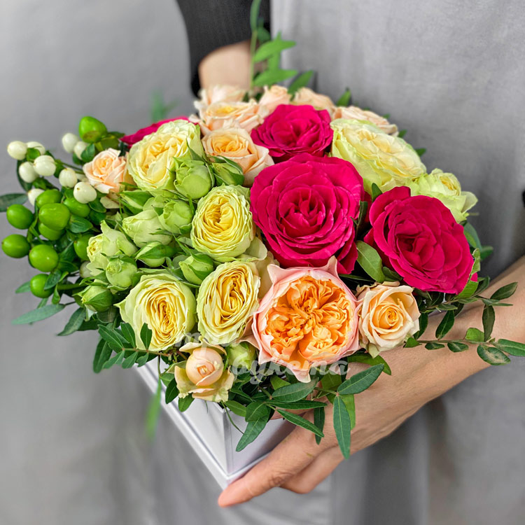 Коробка персиковых и розовых пионовидных роз (вид сбоку)